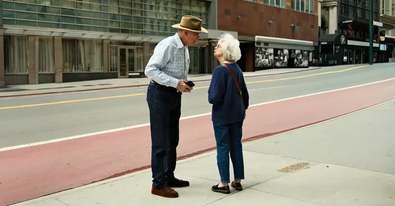 A husband and wife chatting on the sidewalk