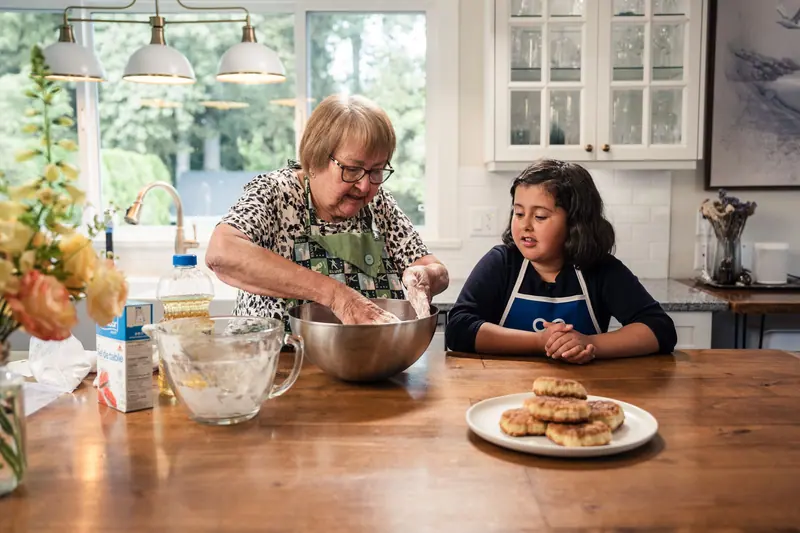 A grandmother and granddaughter baking in the teaching kitchen