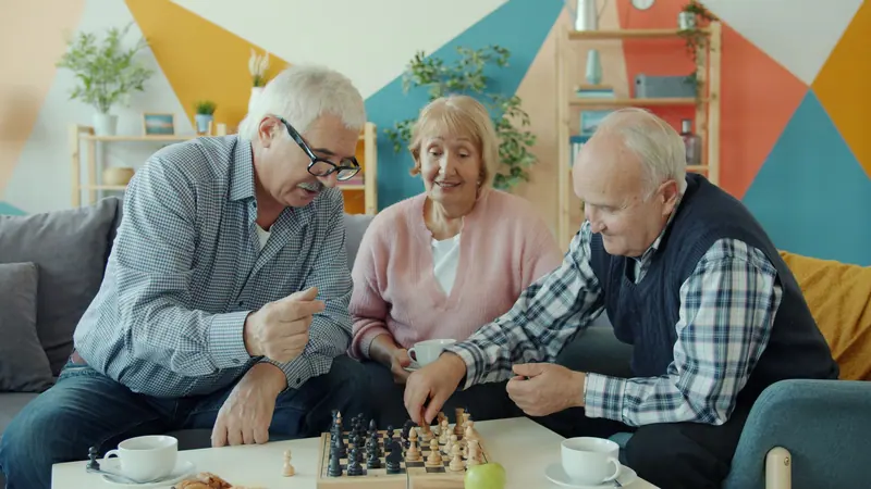 Three friends at a board game in the clubhouse
