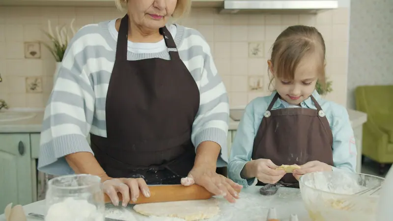 A grandmother baking with her granddaughter