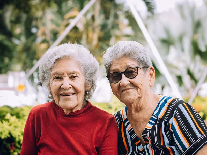 Two lifelong friends smiling in the garden