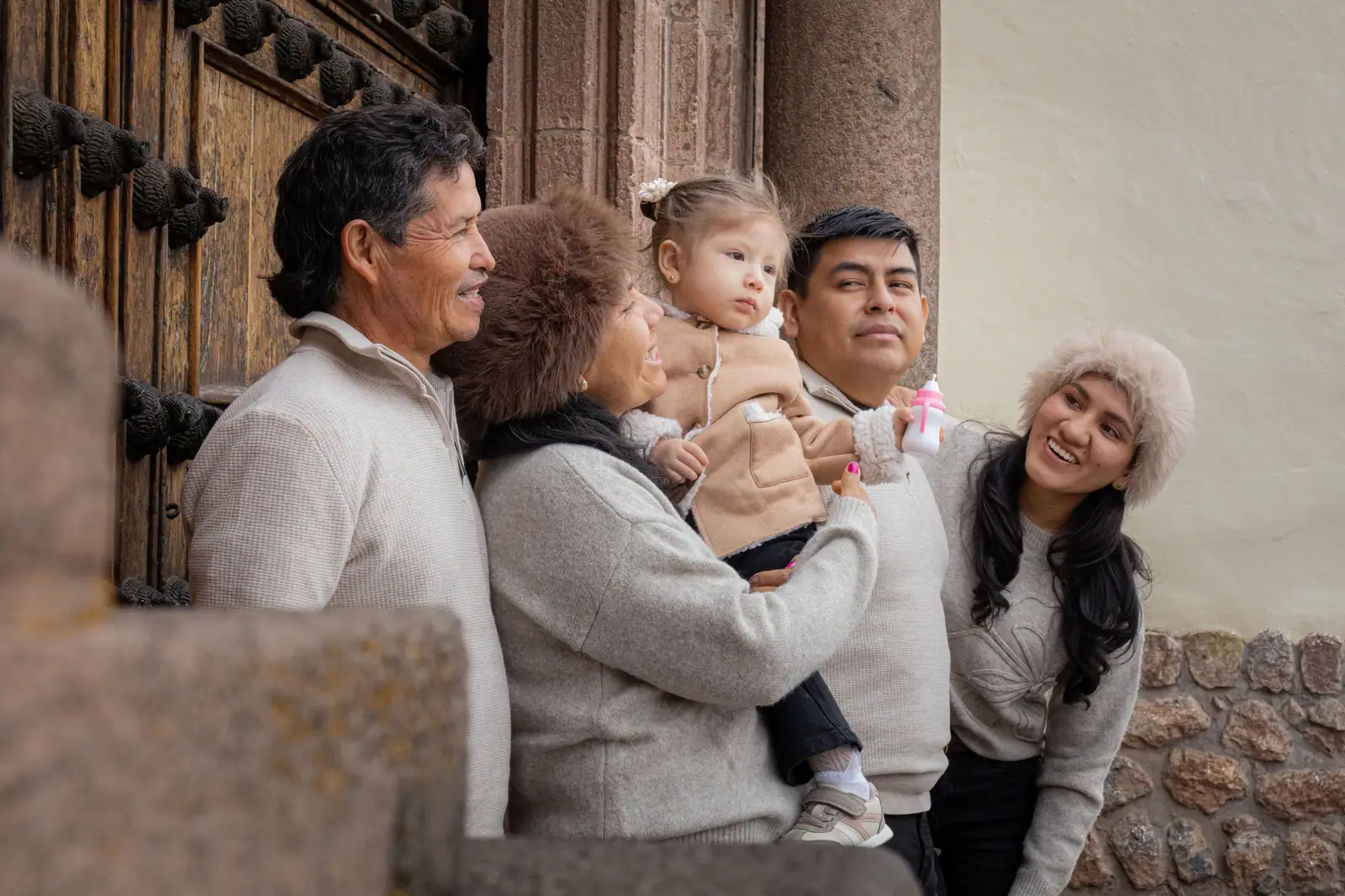 Three generations gathered at the old wooden door of Hargrave House