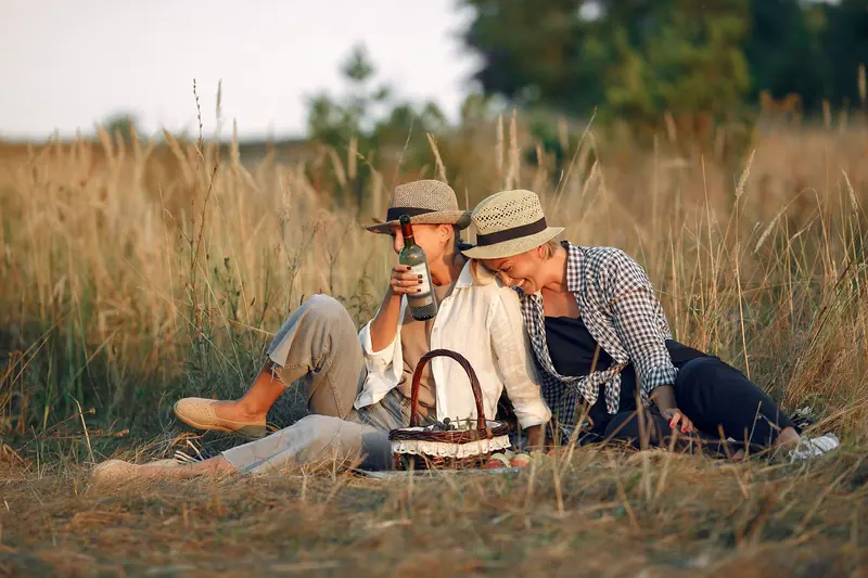 Two friends sharing wine in the tall grass