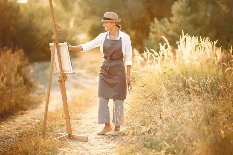 A resident painting in a summer field