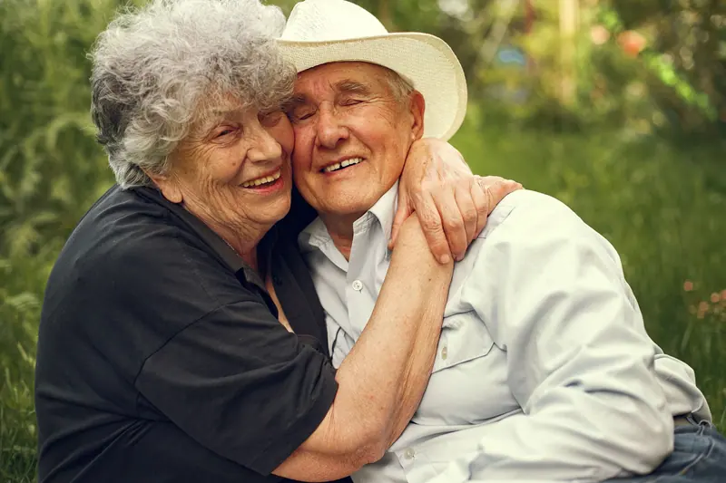 A couple hugging and laughing outdoors