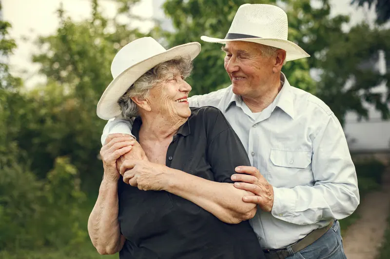 A rancher and his wife laughing together in the summer grass