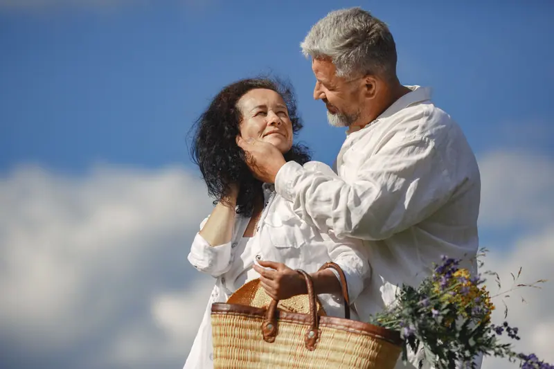 A husband gazing at his wife as she holds a basket of wildflowers