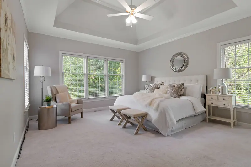A spacious contemporary bedroom featuring elegant furnishings and abundant natural light.