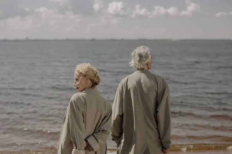 A couple in trench coats on a breezy day