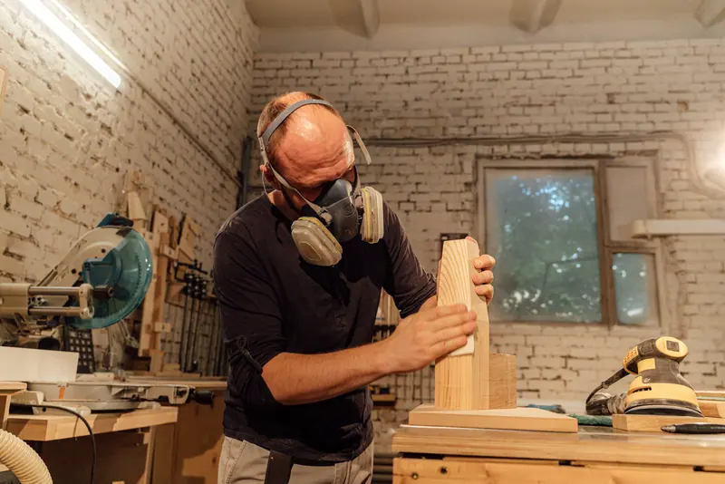 A resident sanding a bench in the shop