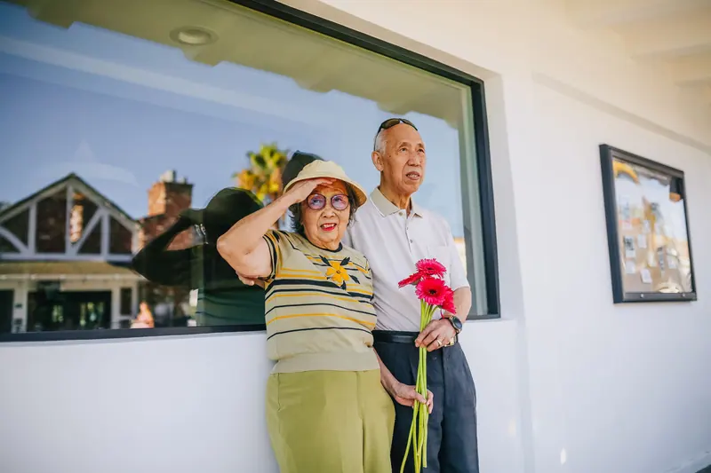 A couple outside with red flowers