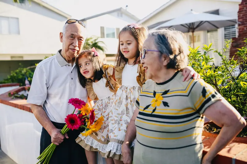 Grandparents greeting their grandchildren with flowers