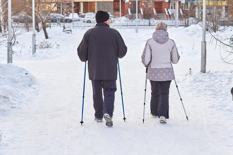 A couple walking with poles on a winter path