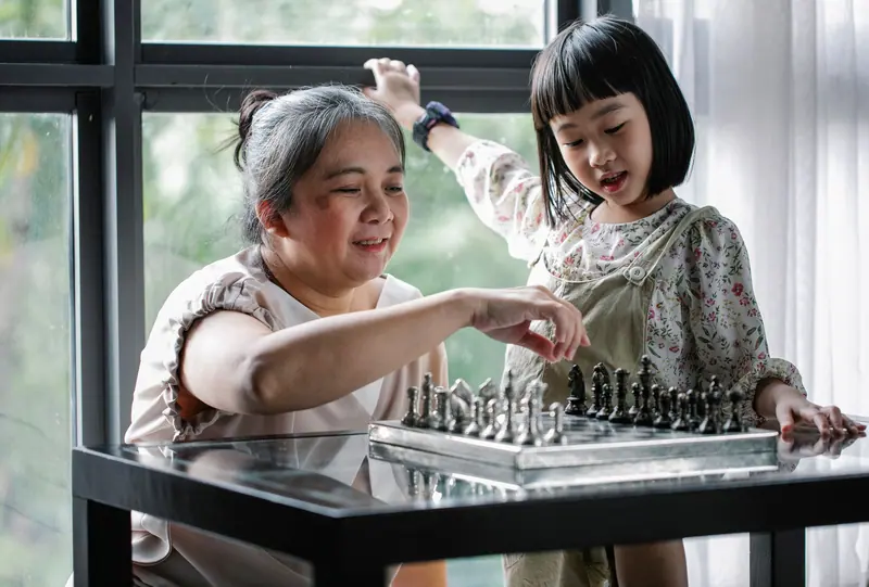 A grandmother and granddaughter playing chess