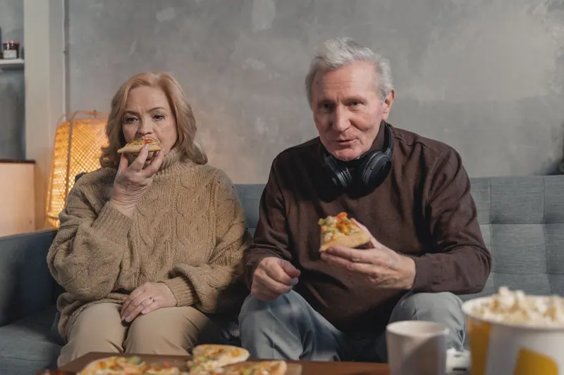 A couple sharing pizza on game night