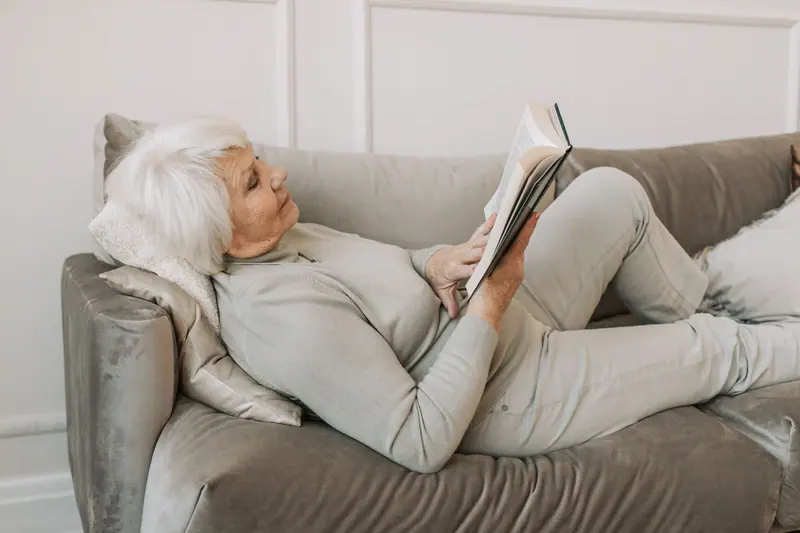 A resident reading on her sofa