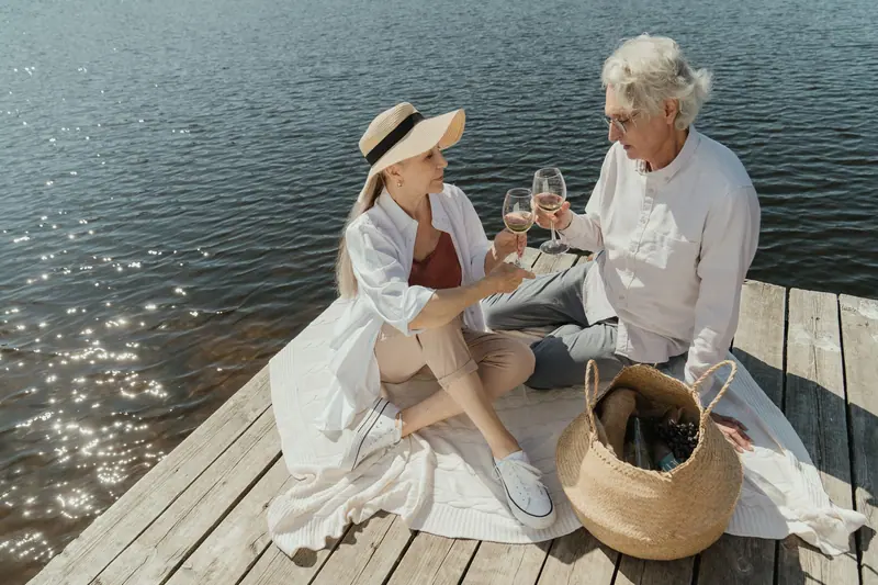 A couple toasting at a lakeside picnic