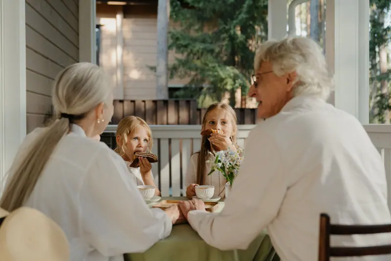 Three generations sharing supper on a screened porch