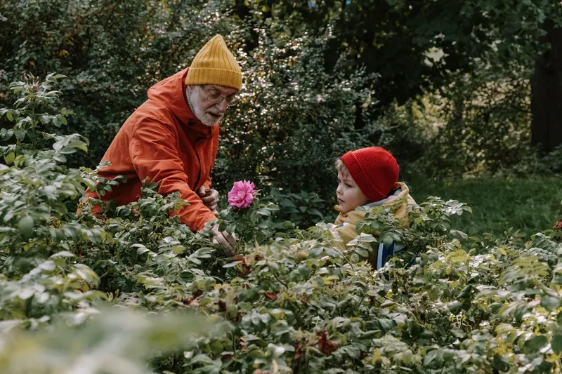 A grandfather showing his grandson the garden