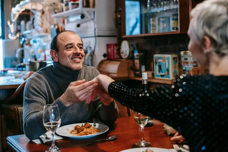 Friends sharing a pasta dinner at a resident's apartment