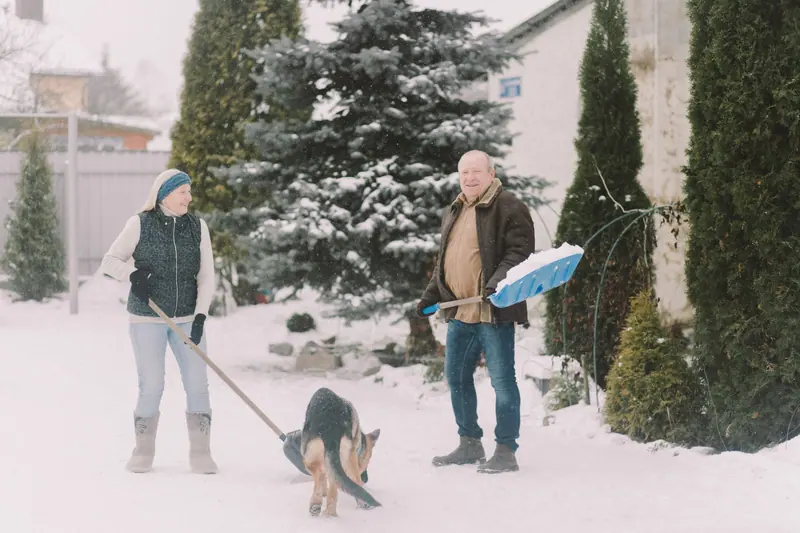 A couple and their dog out in the snow