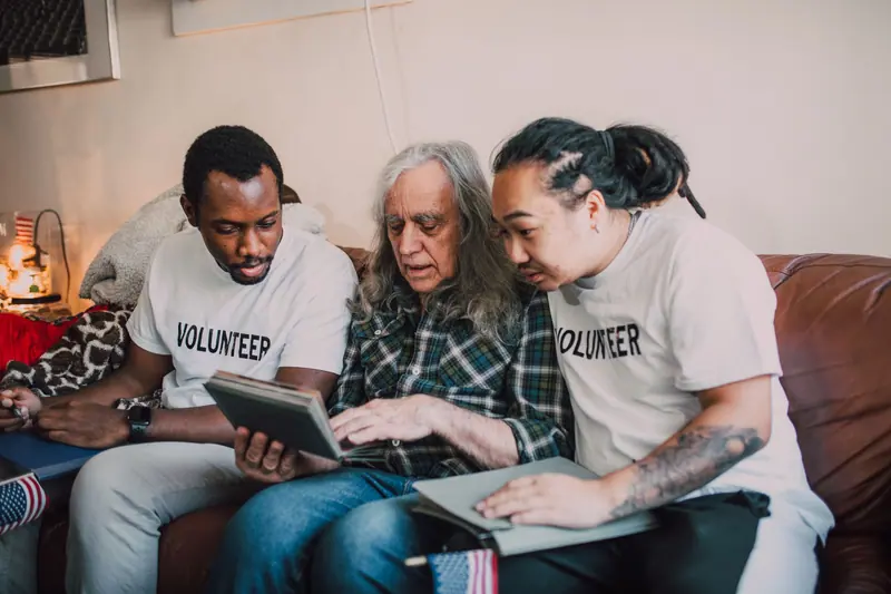 A volunteer looking at an old photo album with a resident