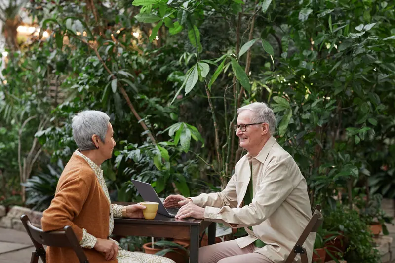 A couple with coffee and a laptop on the patio