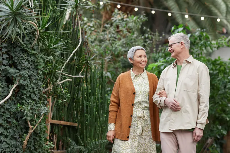 A couple walking through the greenhouse arm in arm
