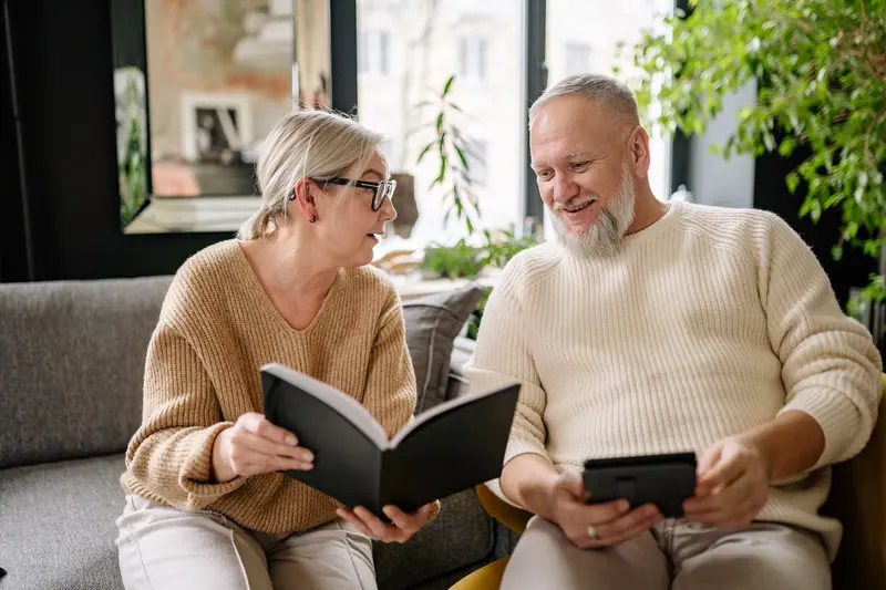 A couple reading together on the sofa