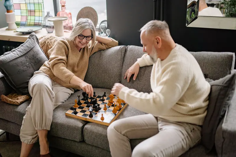 A couple in the middle of a chess game in the parlor