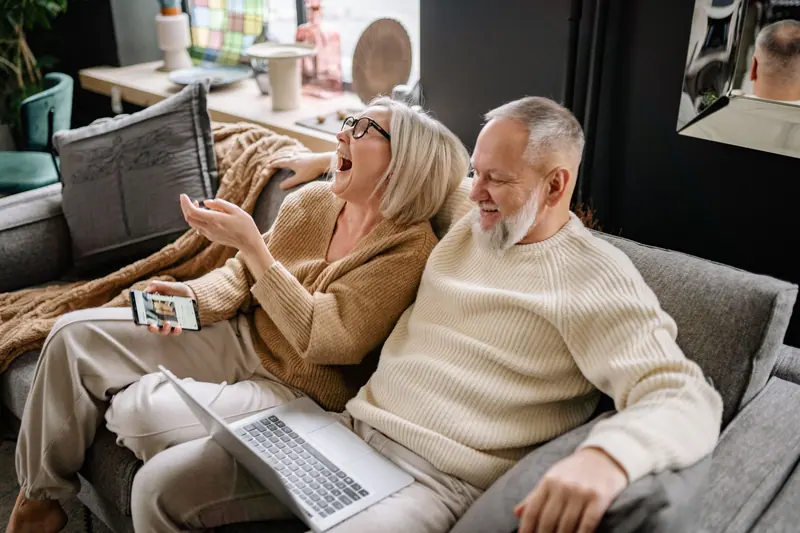 A couple laughing on the sofa
