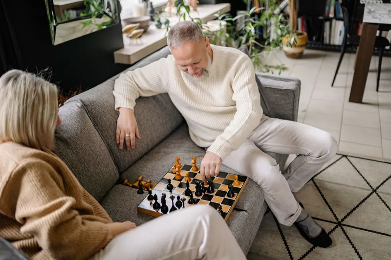 A couple playing chess on the sofa