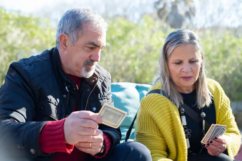 A couple playing cards outdoors