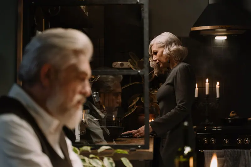 A husband and wife cooking supper by candlelight in their apartment kitchen