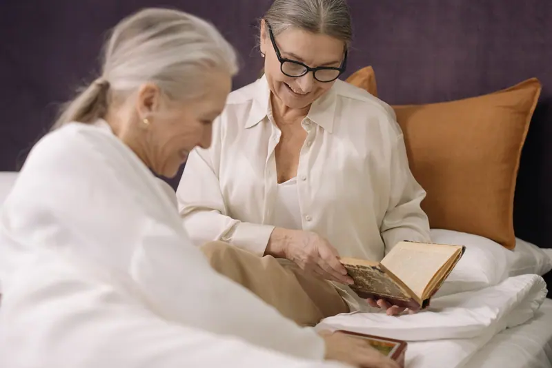 Two friends sharing a book on the sofa