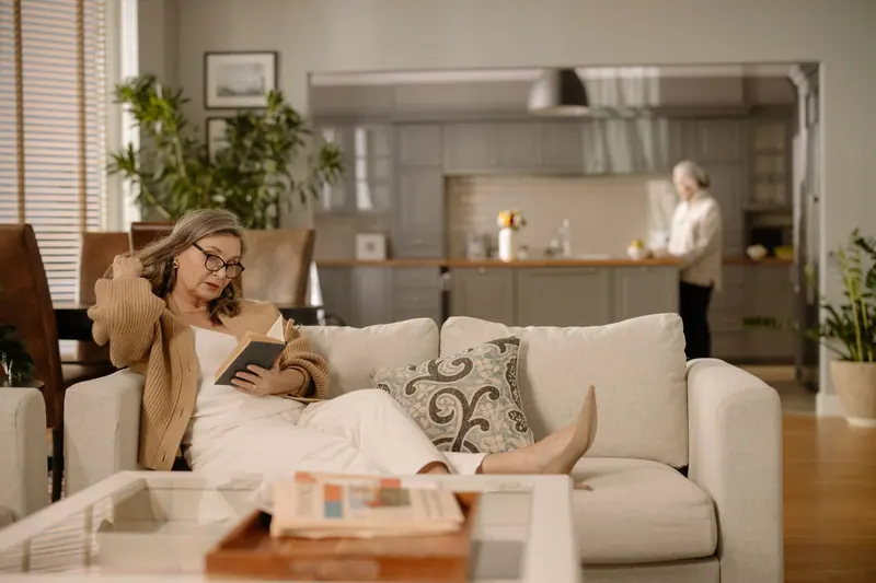 A resident with a book on the couch