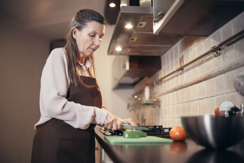 A resident chopping vegetables for supper