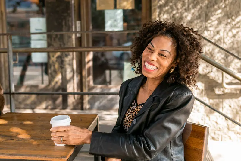 A resident laughing over her morning coffee