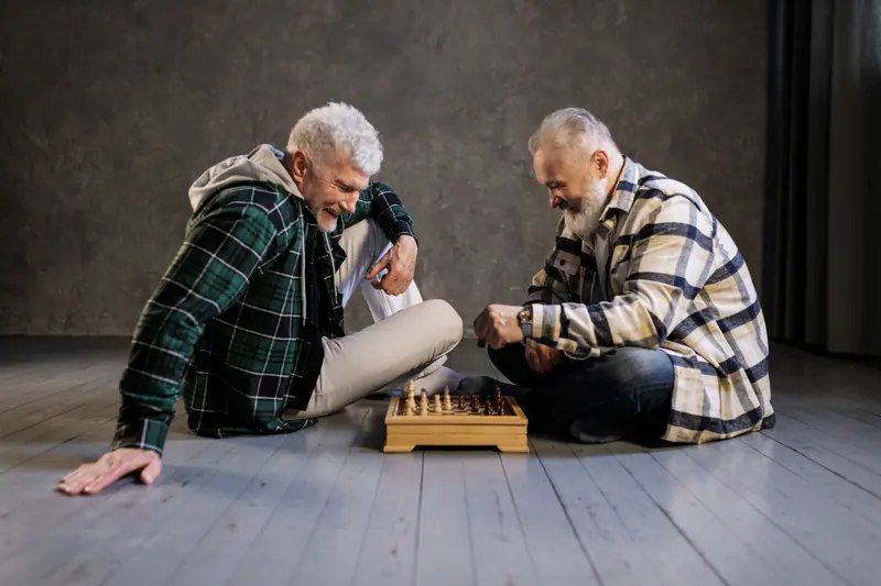 Two residents laughing over a chess game