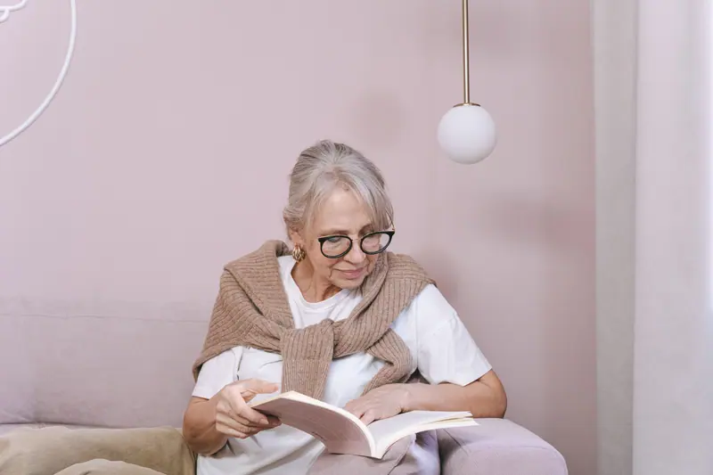 A resident reading on her sofa