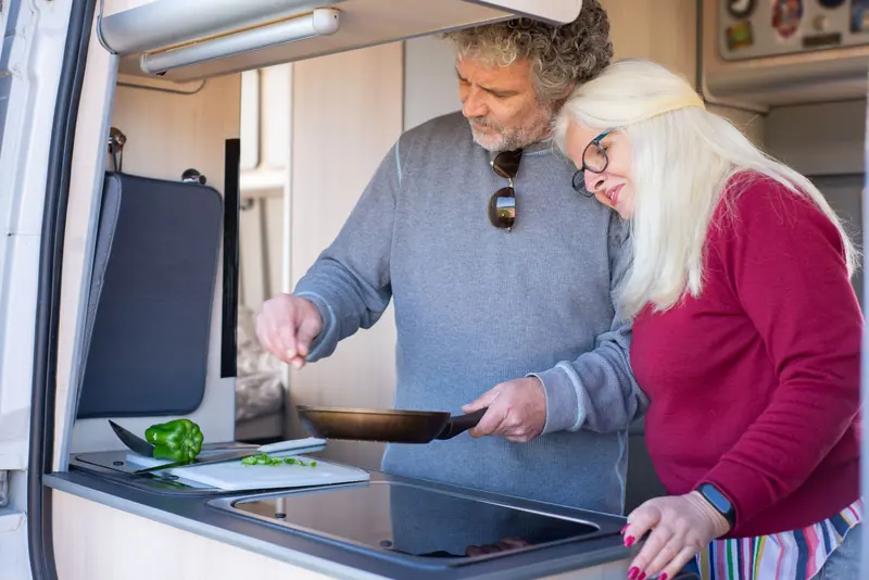 A couple cooking supper together in their cottage kitchen