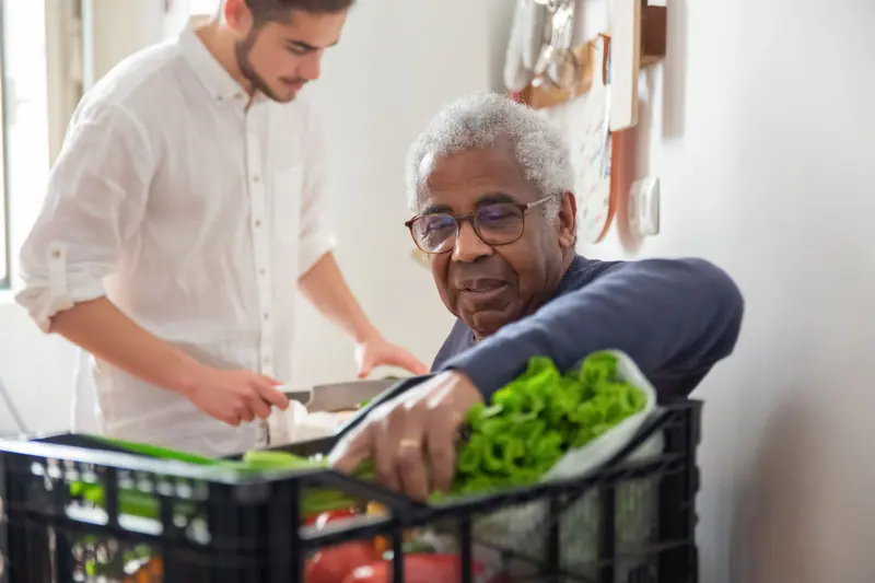 A volunteer helping a resident with groceries