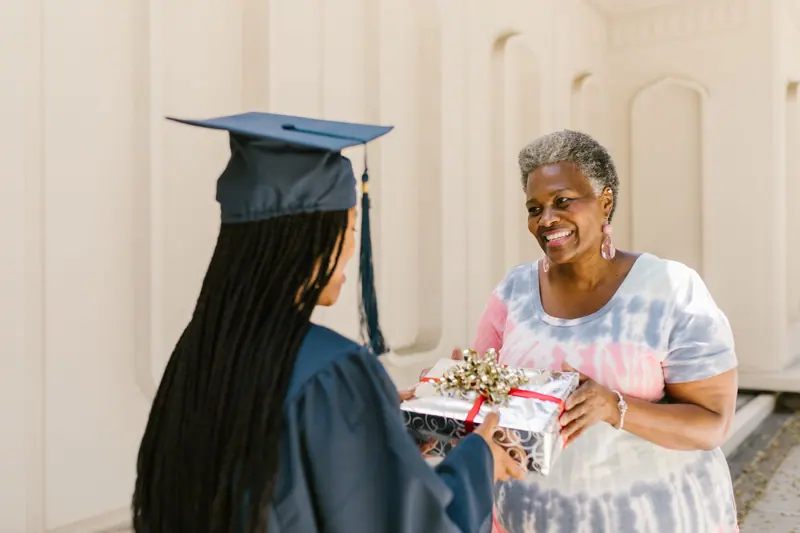 A grandmother giving her granddaughter a graduation gift