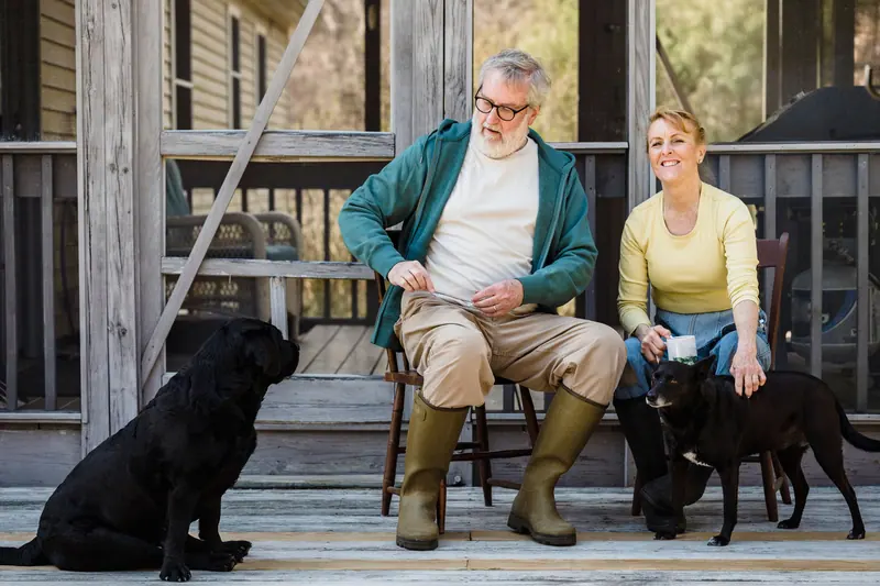A couple on the porch with their dogs