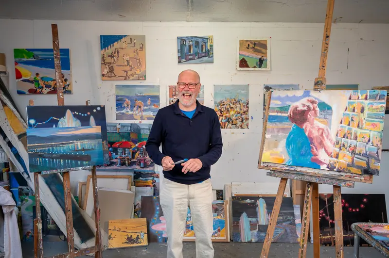 A resident in the gallery among his paintings
