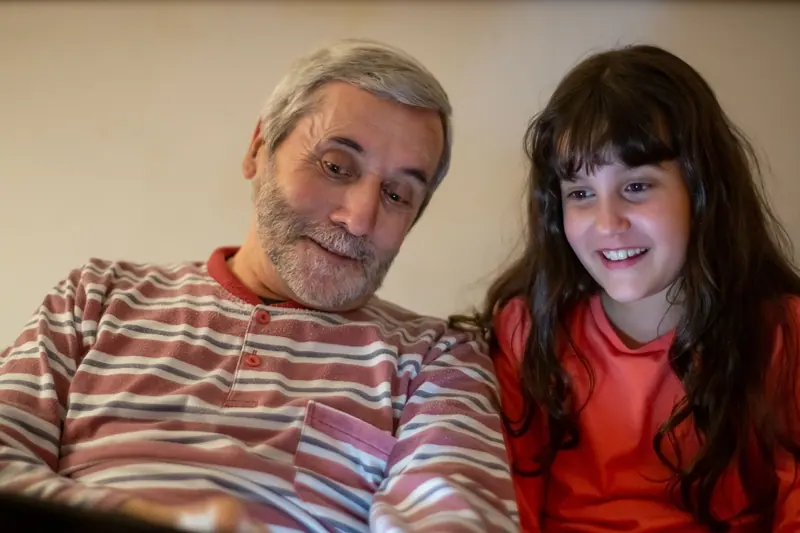 A grandfather and granddaughter with a tablet