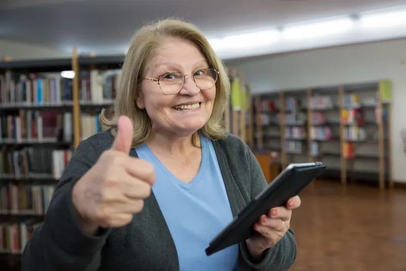 A resident giving a thumbs up from the library computer class