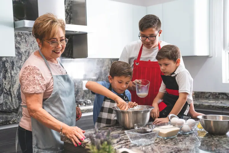 A grandmother baking with her grandsons in the family kitchen