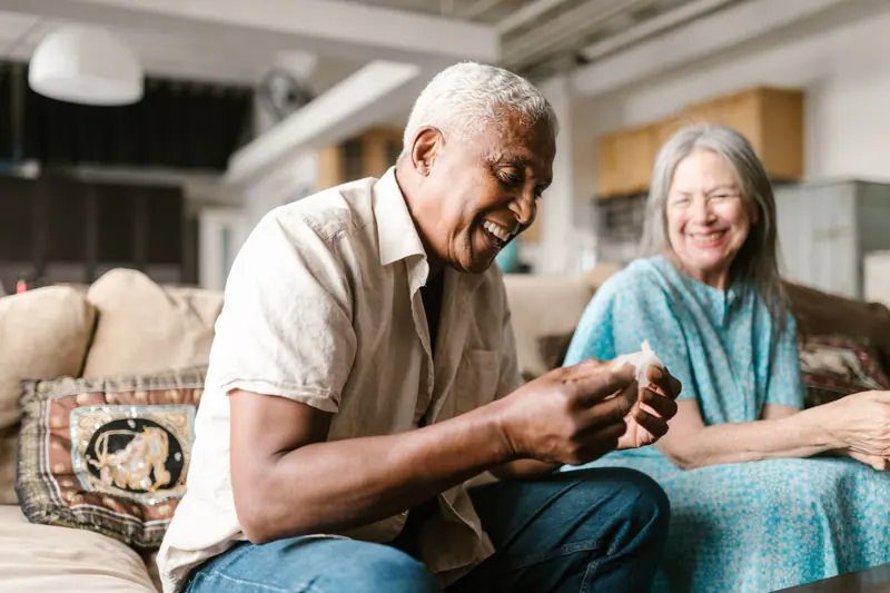 A couple laughing on the sofa
