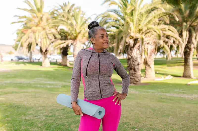 A resident with her yoga mat in the park
